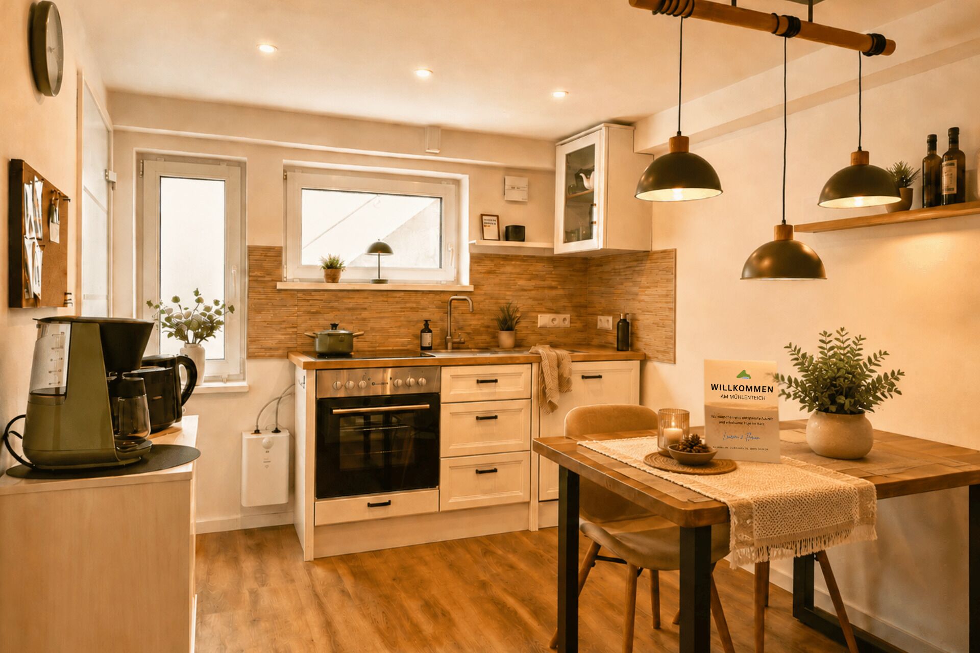 A compact kitchen with a stove, oven, and sink, a dining area with a table and chairs, and a window with a view.