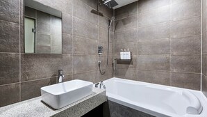 Ein modernes Badezimmer mit einem rechteckigen Waschbecken, einer Badewanne und einer Dusche.