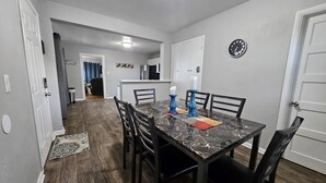 A dining area with a marble table, black chairs, and a clock on the wall. - Cozy Retreat Near Pikes Peak & Downtown (Colorado Springs)