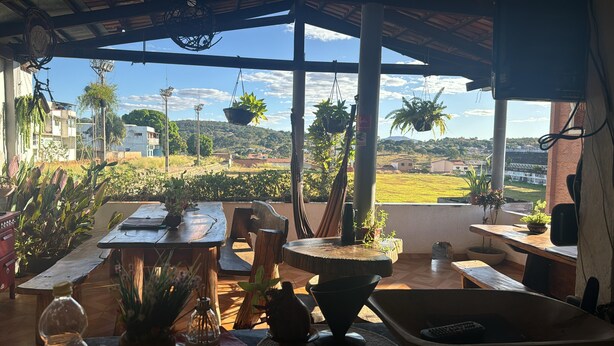 Un espacio de estar al aire libre cubierto con vistas a un paisaje rural, que incluye campos y edificios lejanos.