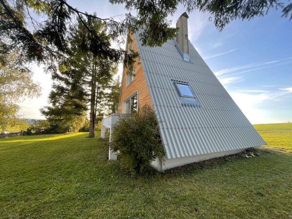 A modern house with a sloped roof, a small window, and a chimney. - Beautiful holiday home surrounded by nature (Les Enfers)