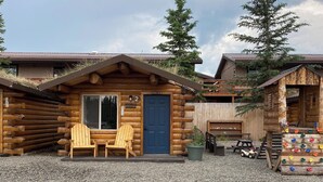A rustic log cabin with a blue door, numbered room 2, and two wooden Adirondack chairs outside. - Angler Cabin-Modern Comfort in the Last Frontier (For families or casual travelers) (Tok)