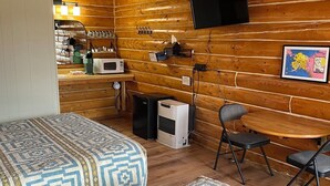 A cozy log cabin room with a bed, a desk, a chair, a television, and a microwave. - Angler Cabin-Modern Comfort in the Last Frontier (For families or casual travelers) (Tok)
