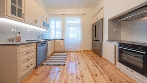 A modern kitchen with wooden cabinets, stainless steel appliances, and a marble countertop. - Eleofilos Old Town (Lesvos)