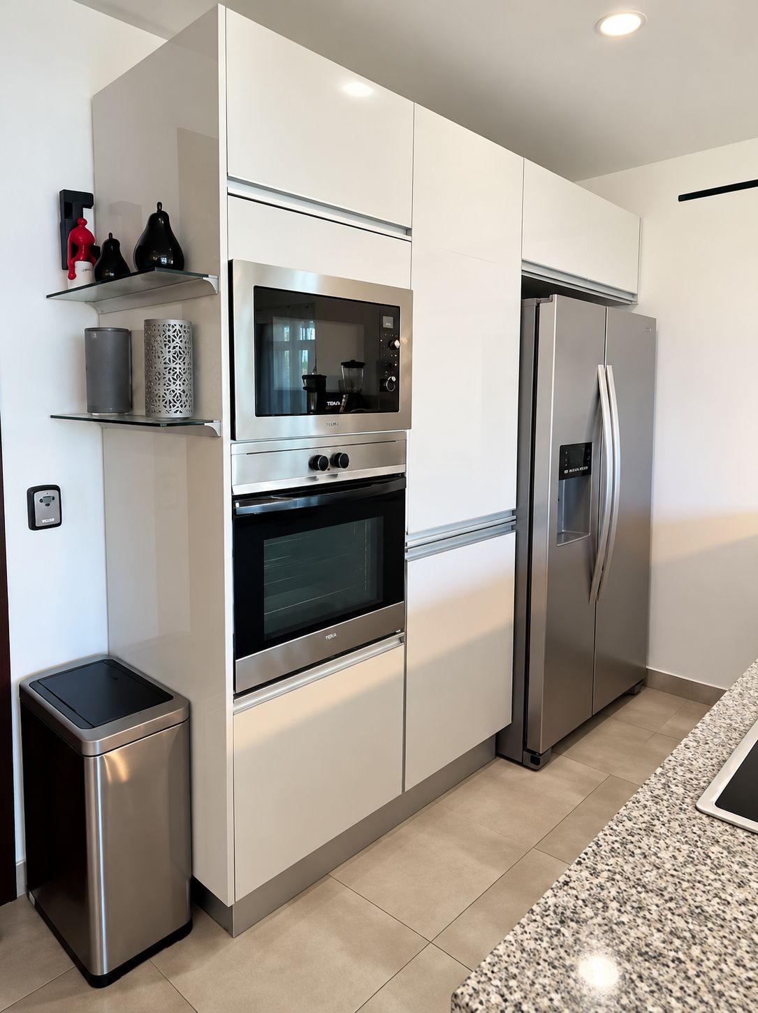 A modern kitchen with stainless steel appliances, including a refrigerator, oven, and microwave.