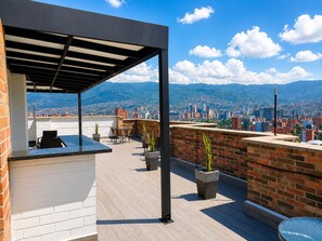 A rooftop terrace with a bar area, seating, and potted plants. - penthouse jacuzzi rooftop fun in the sun (Medellín)
