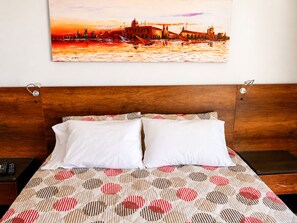 A hotel room with a wooden headboard, a bed with white pillows, and a patterned bedspread. - penthouse jacuzzi rooftop fun in the sun (Medellín)