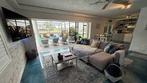 Ein geräumiges Wohnzimmer mit einer großen Eckcouch, einem Couchtisch und Blick auf die Außenpatio-Terrasse.