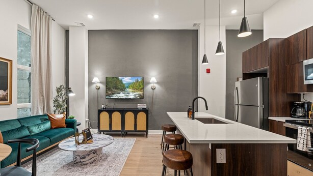 A modern kitchen with a central island, bar stools, and a built-in oven. - Sleeps 4 Walk to Liberty Bell Heart of Old City (Philadelphia)