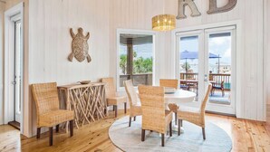 Una habitación con muebles de mimbre, una mesa redonda y una lámpara en el techo.