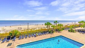 A pool area with lounge chairs and a view of the beach. - Oceanfront Sea and Sky Haven! (Myrtle Beach)