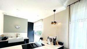 A modern kitchen with a marble countertop, a built-in oven, and a coffee machine. - House 5 rooms 6 people, beach and port of Larmor nearby - wifi (LARMOR-PLAGE)