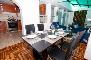 A modern kitchen with a built-in oven and a dining area with a table set for four.