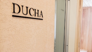Segnaletica con la scritta 'DUCHA' su una parete strutturata, che indica un albergo o una struttura ricettiva.