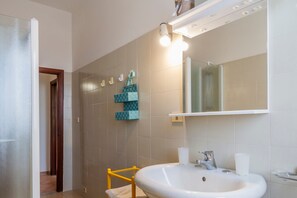 A bathroom with a white sink, a mirror, and a towel rack.
