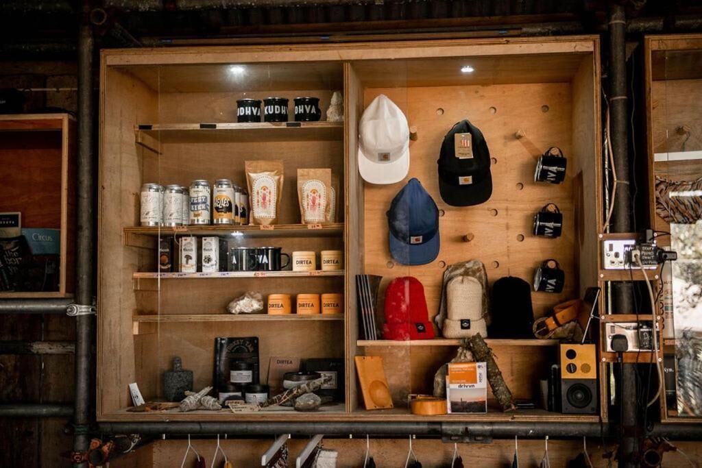 A wooden display case with various items including hats, bags, and containers.