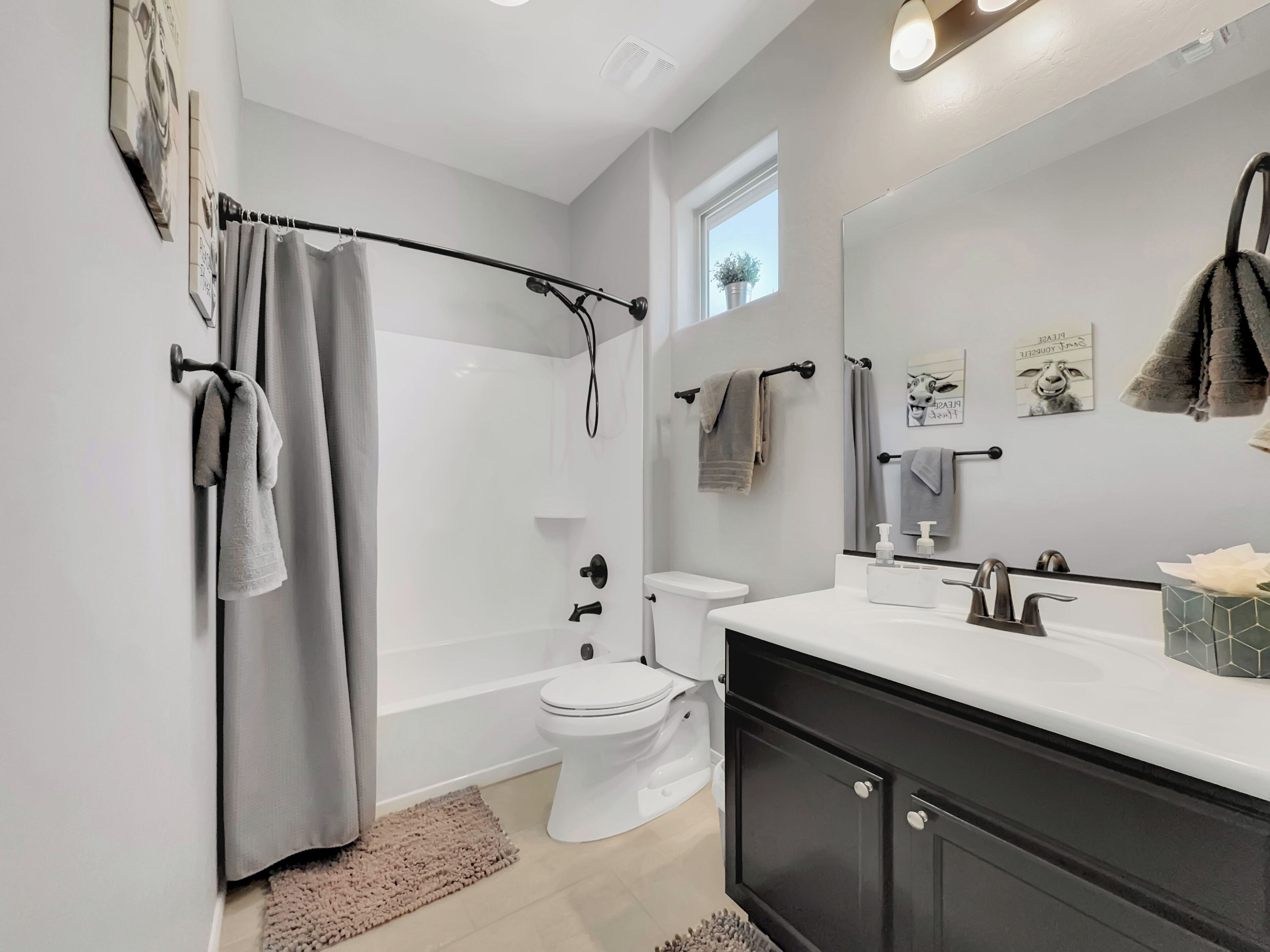 A modern bathroom with a shower, toilet, and vanity.