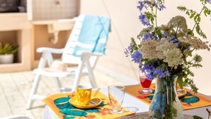 Ein Tisch ist gedeckt, mit einem Blumenstrauß, einer gelben Tasse und einem Glas auf einer Tischdecke.