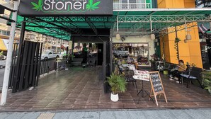 A storefront with a sign reading "Stoner" and a menu board outside. - Green Hotel (Pattaya)