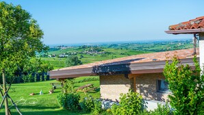 A house with a stone facade and a red-tiled roof overlooking a green valley. - Villa 'Elios' with Mountain View, Wi-Fi and Air Conditioning (Unknown)