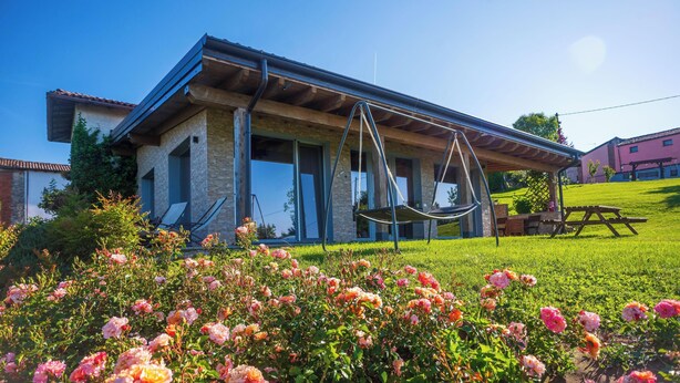 A house with a patio, a swing, and a garden with roses. - Villa 'Elios' with Mountain View, Wi-Fi and Air Conditioning (Unknown)