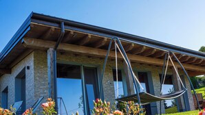 A modern building with a stone facade, large windows, and a hammock suspended from the ceiling. - Villa 'Elios' with Mountain View, Wi-Fi and Air Conditioning (Unknown)