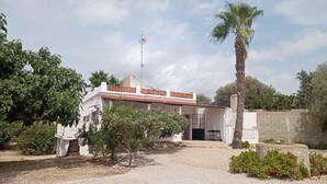 A white building with a red-tiled roof, a small porch, and a palm tree in the foreground. - Villa Pablo - Chalet en Vinaròs - Ref. 017 (Vinaròs)