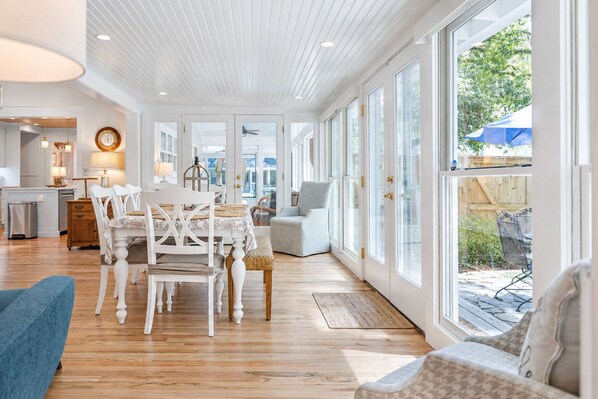 A spacious interior with a dining area, kitchen, and large windows.
