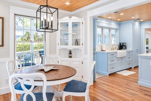 A kitchen with white cabinets, a wooden dining table, and blue accents.
