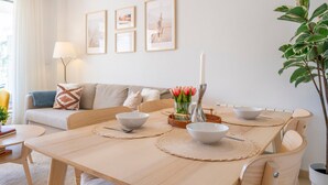 A dining area with a wooden table, white bowls, and a candle centerpiece.