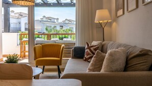 A modern living room with a sofa, armchair, and a floor lamp.