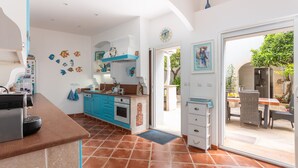 Eine Küche mit blauen Schränken, einem eingebauten Backofen und einem großen Fenster.