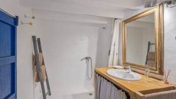 Un baño con bañera, lavamanos, espejo y toallero.