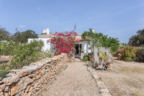 A stone wall, a gravel path, and a white building with a door. - Country Cottage 'Vicent' with Private Terrace and Garden (Illes Balears)