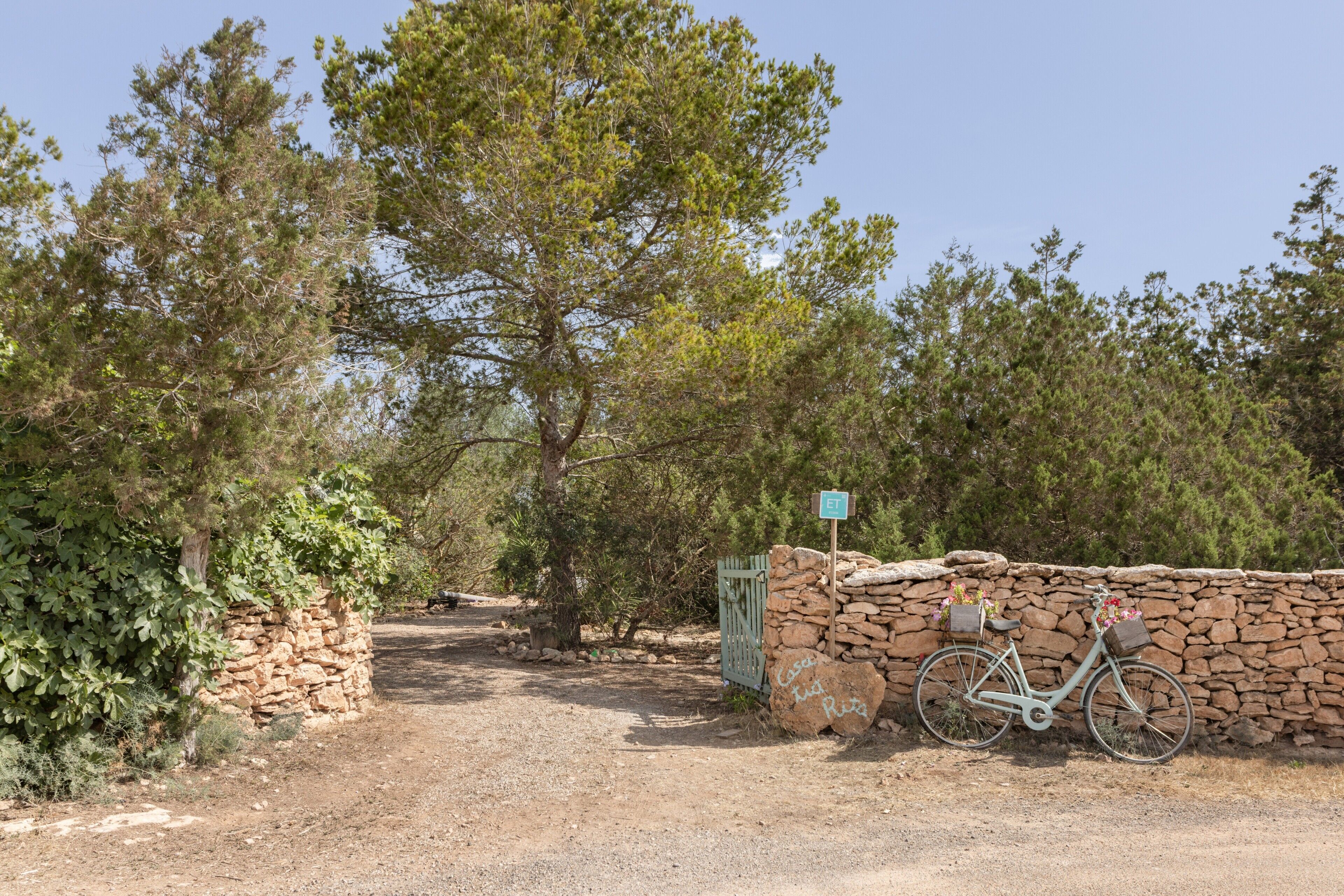 Un mur de pierres, un vélo et un panneau sur lequel on peut voir les lettres « ET ».