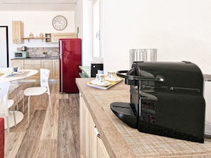 A compact kitchen with a red refrigerator, a coffee maker, and a microwave.