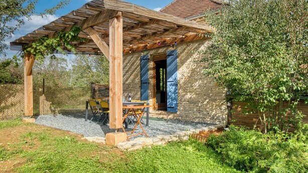 A rustic stone house with a wooden pergola, a stone pathway, and a small outdoor seating area. - Les Jardins de Boscornut – Organic Farm Cottage near Hautefort in Périgord Noir (Sainte-Orse)