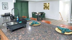 A kitchen with granite countertops, a sink, and a dining area with chairs and a table. - Upscale 3-bedroom/2.5-bath unit near EWR, NYC, MetLife, Prudential, and more. (Newark)