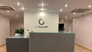Una recepción con logotipo y nombre, diseño moderno y piso de baldosas.