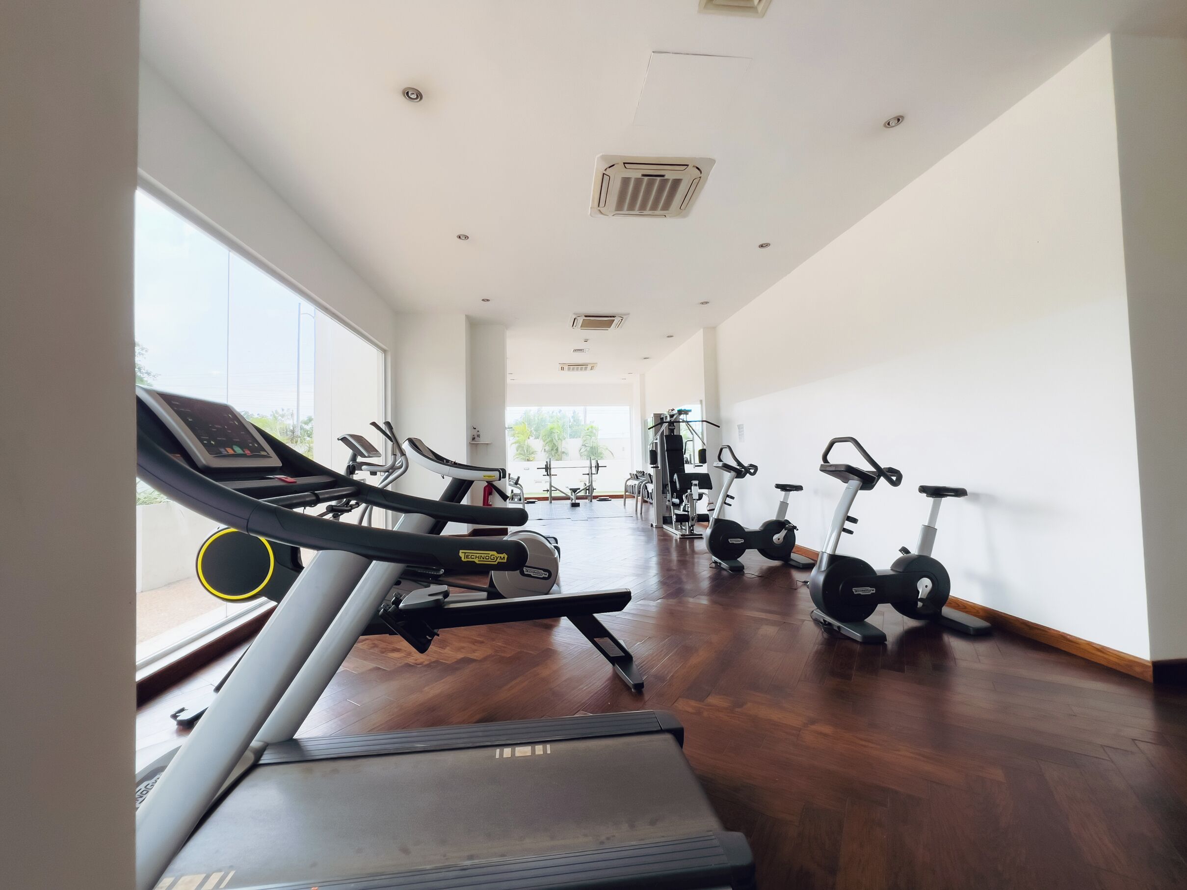 Un gimnasio con cintas de correr, bicicletas estáticas y equipo de ejercicio.