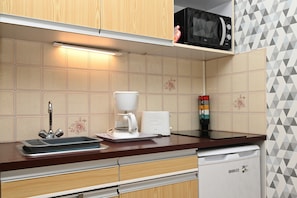 Una cucina con forno a microonde, macchina da caffè e lavastoviglie.