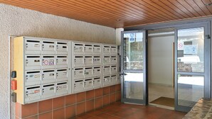 Una hilera de buzones, una puerta de entrada de vidrio y un suelo de baldosas.