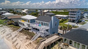 A coastal house with a large balcony, a deck, and a staircase leading to the beach. - Oceanfront Paradise with Amazing Views, Hot Tub! (Surf City)