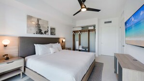 A modern hotel room with a large bed, bedside tables, a ceiling fan, and artwork on the walls. - Limoncello Spritz - Central Miami Pool Gym Spa (Miami)