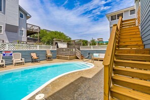 A swimming pool with a wooden deck, lounge chairs, and a wooden staircase. - Sully's Shore Thing Walk to beach Pool hot tub (Corolla)