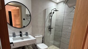 Une salle de bain moderne équipée de toilettes, d’un lavabo et d’une douche.