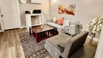 A modern living room with a sofa, coffee table, and a patterned rug.