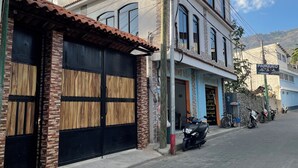 Un edificio de varios pisos con techo de tejas, fachada de ladrillo y grandes ventanales.