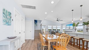 Una cocina amplia con zona de comedor, sillas de madera y un ventanal con vistas.