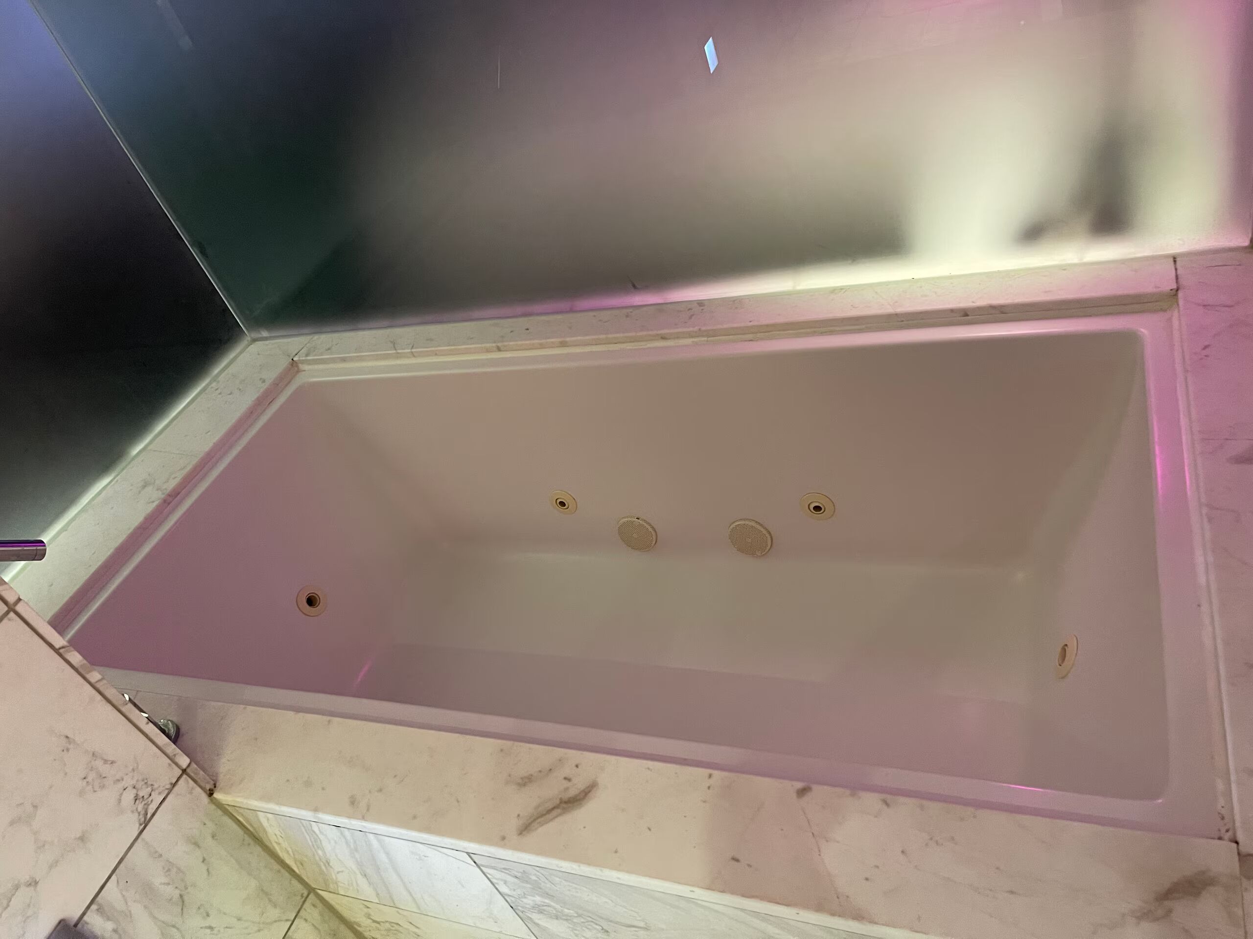 A bathtub with a rectangular shape and a flat bottom.